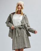 Woman in an oversized, long sleeve, plaid jacket