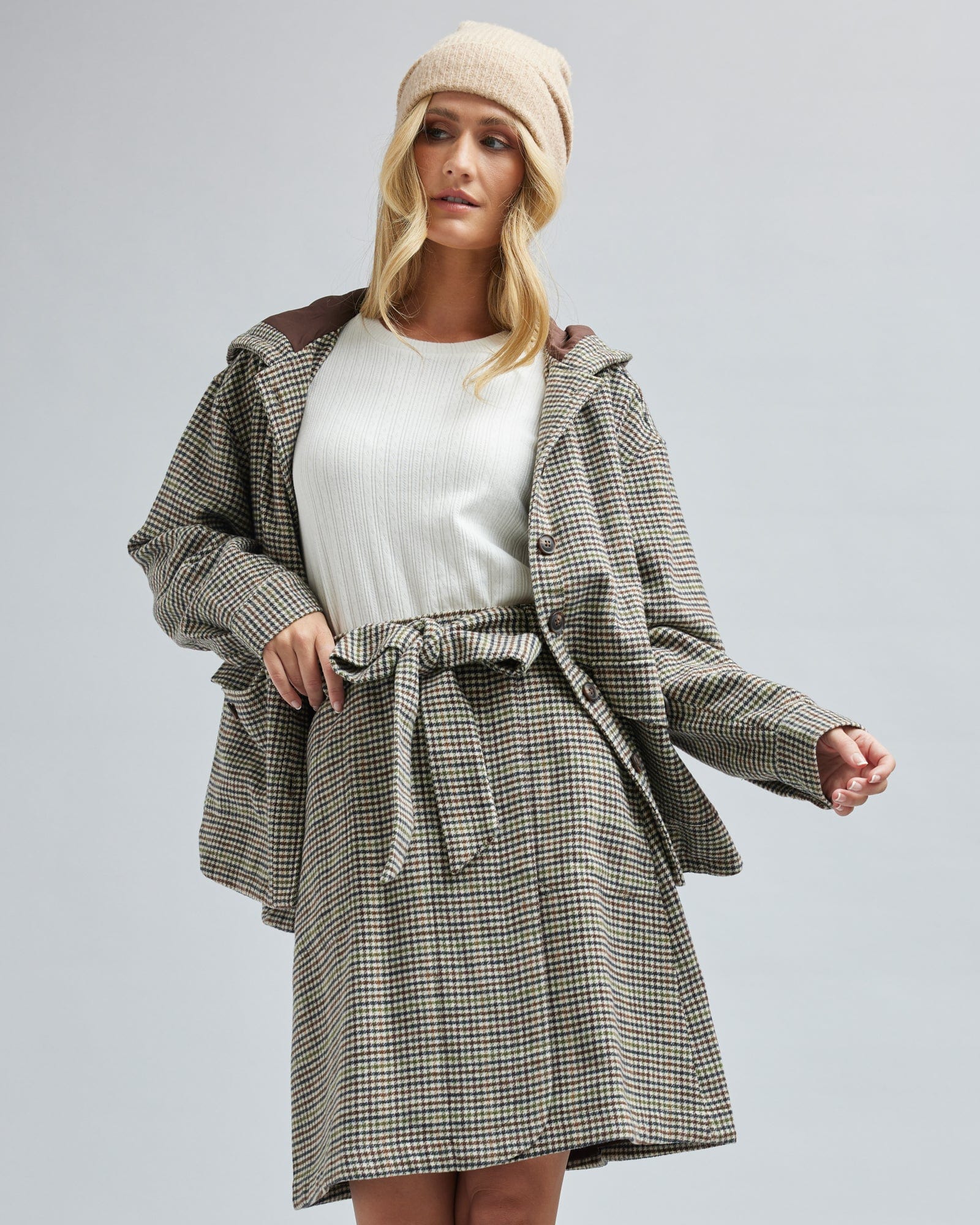 Woman in an oversized, long sleeve, plaid jacket