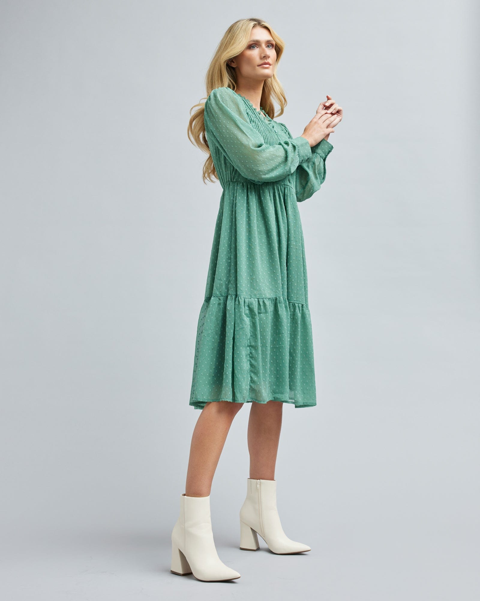 Woman in a long sleeve, green, midi length dress