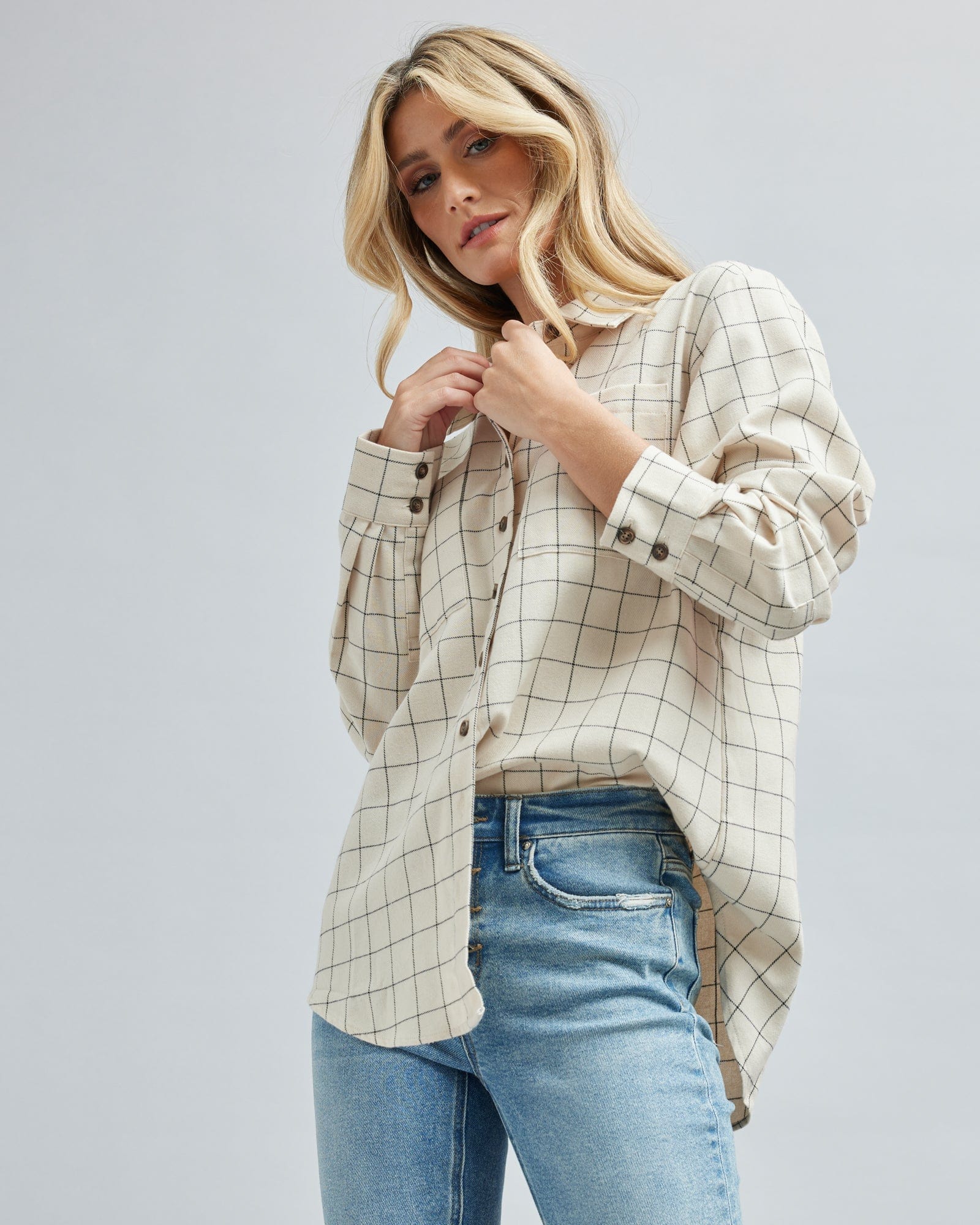 Woman in a long sleeve, plaid, button down blouse