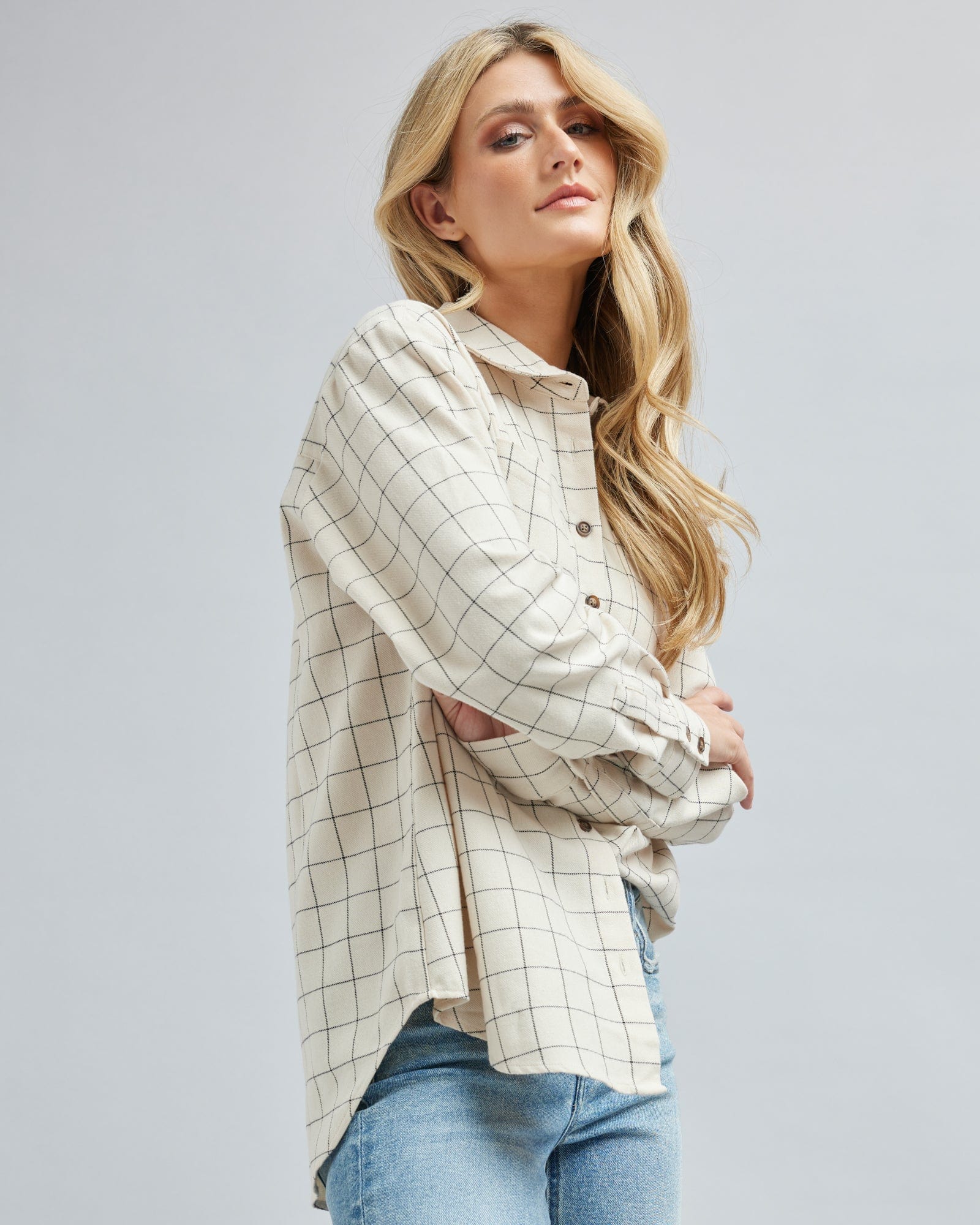 Woman in a long sleeve, plaid, button down blouse