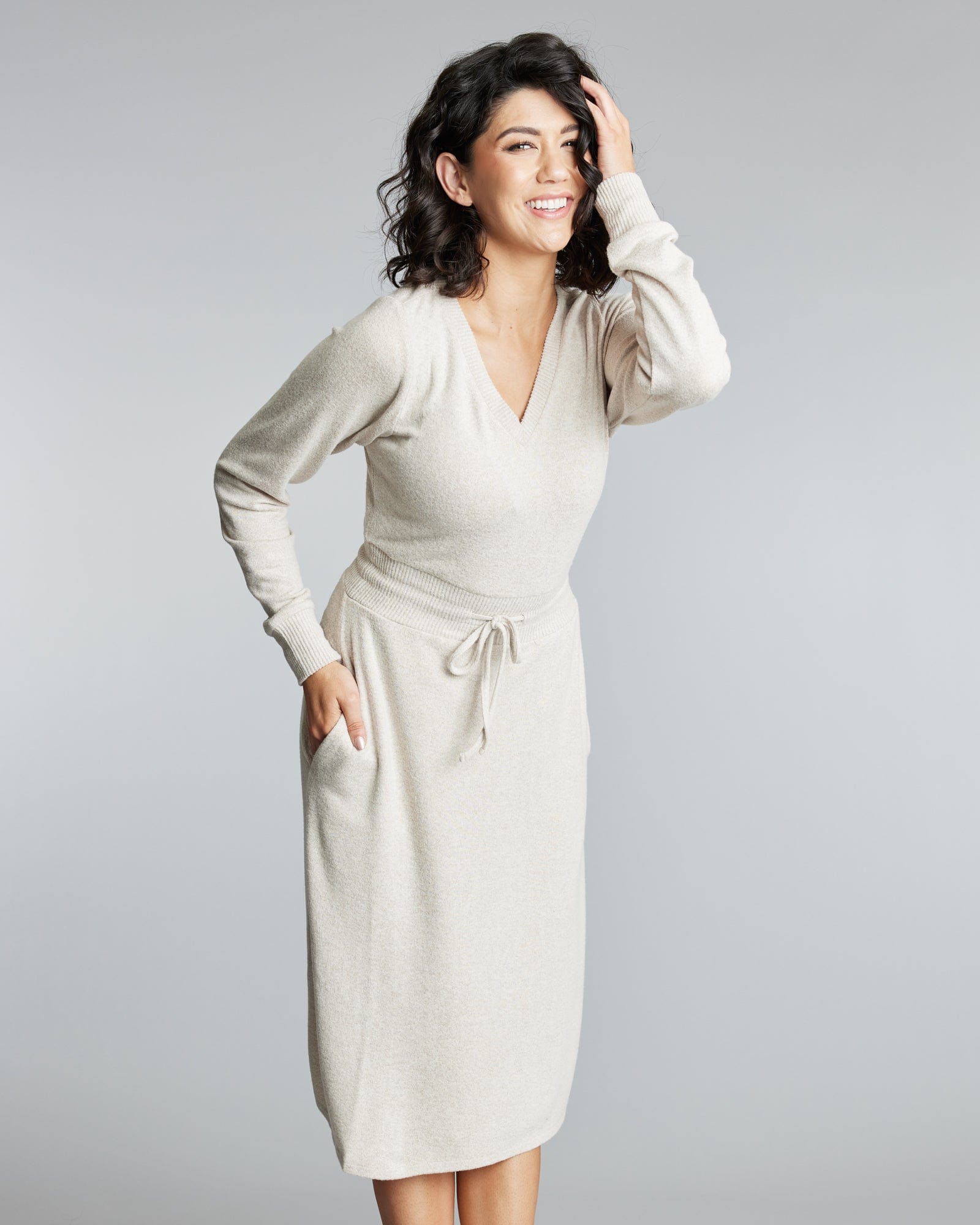 Woman in a long sleeve, knee-length sweater dress