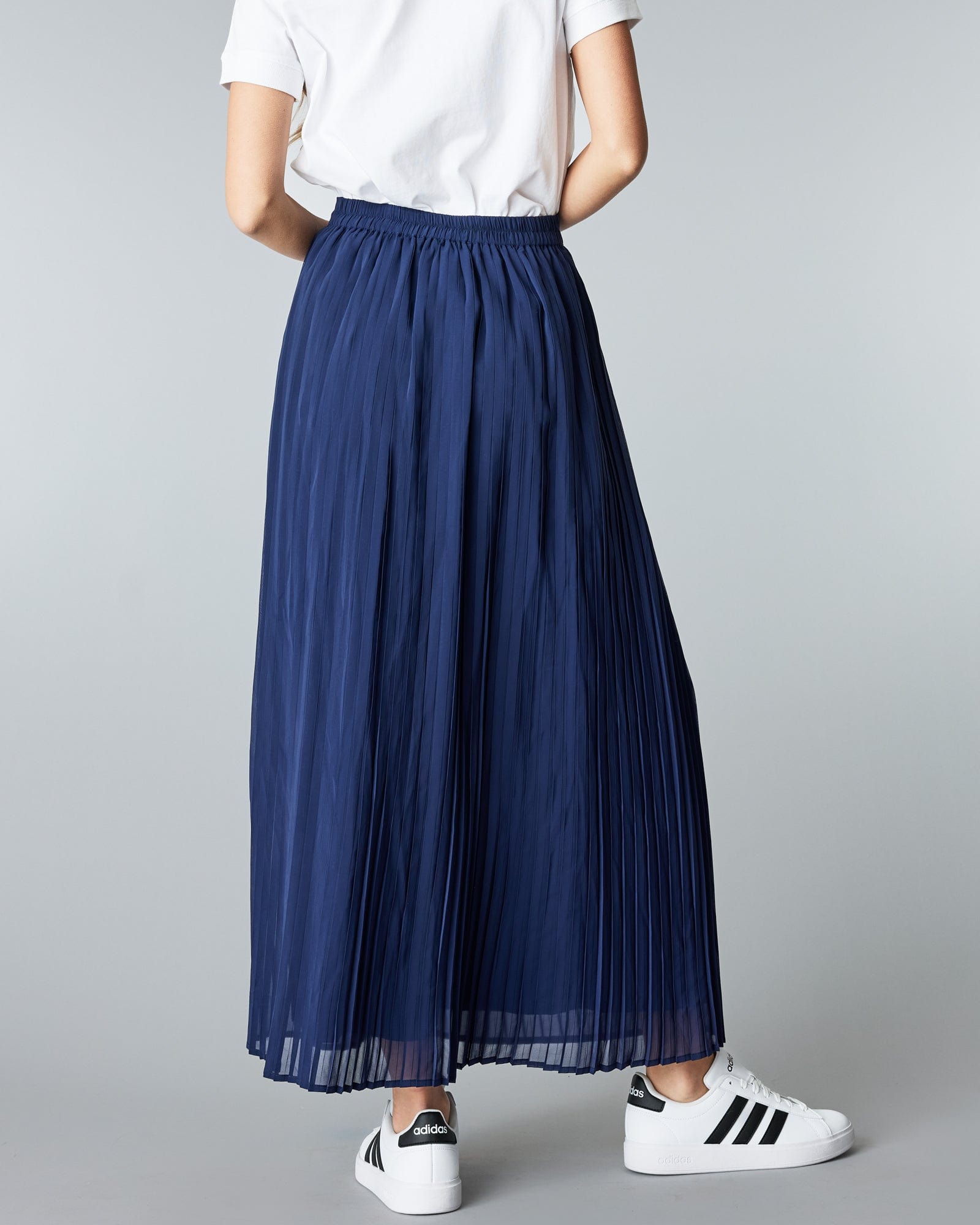 Woman in a maxi length, navy, pleated skirt