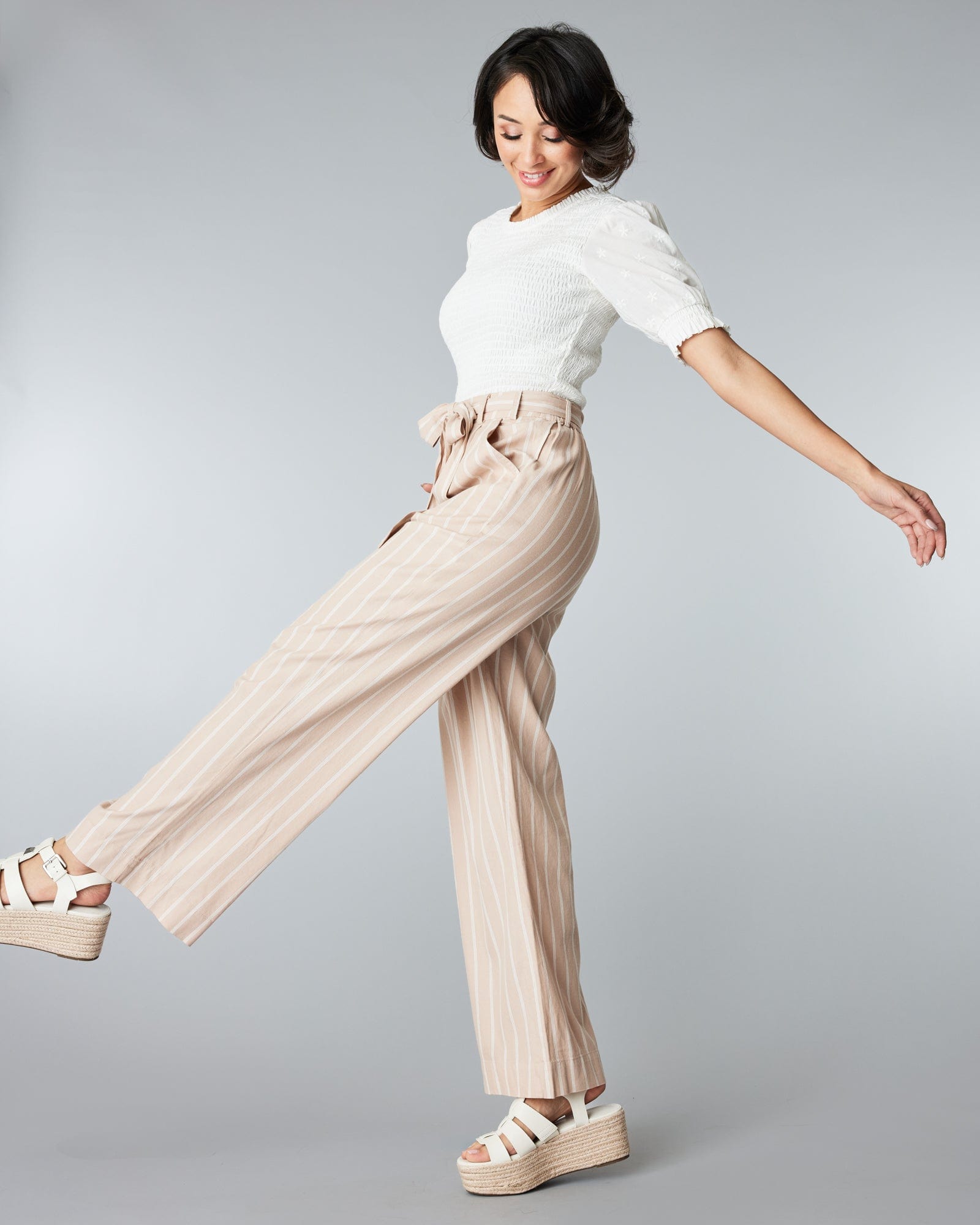 Woman in tan and white striped trousers