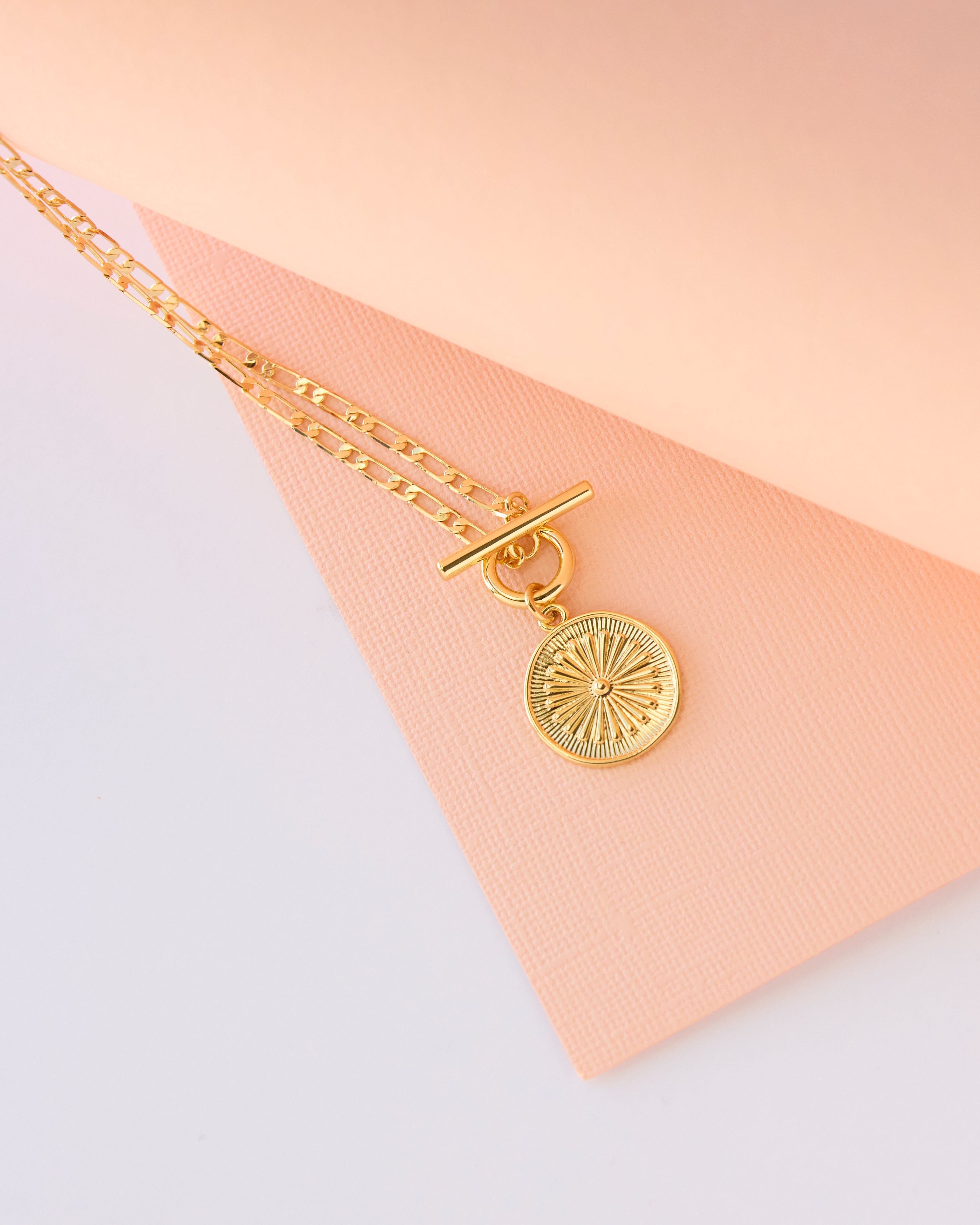 Gold necklace with flower charm.