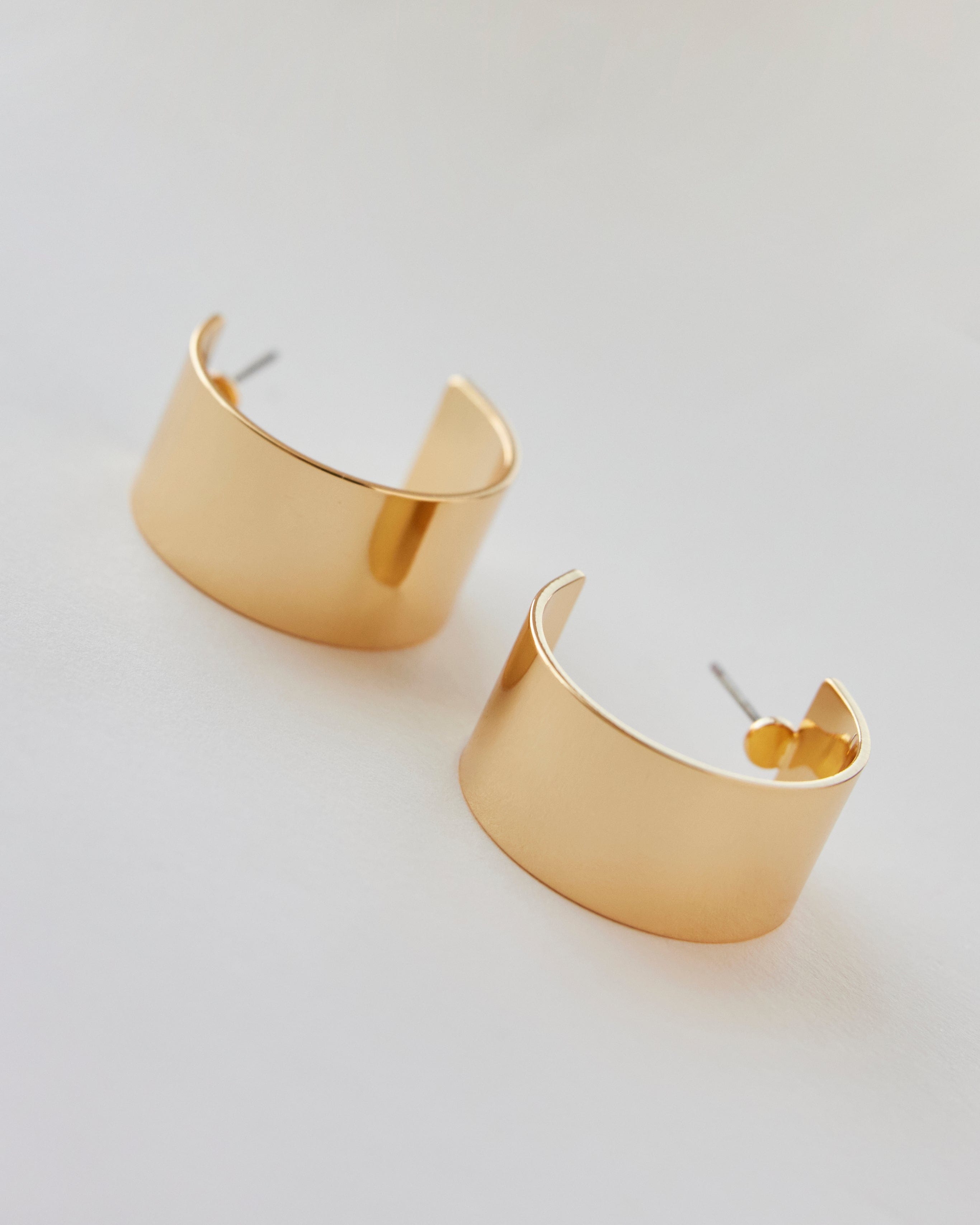 Chunky gold huggie hoop earrings.
