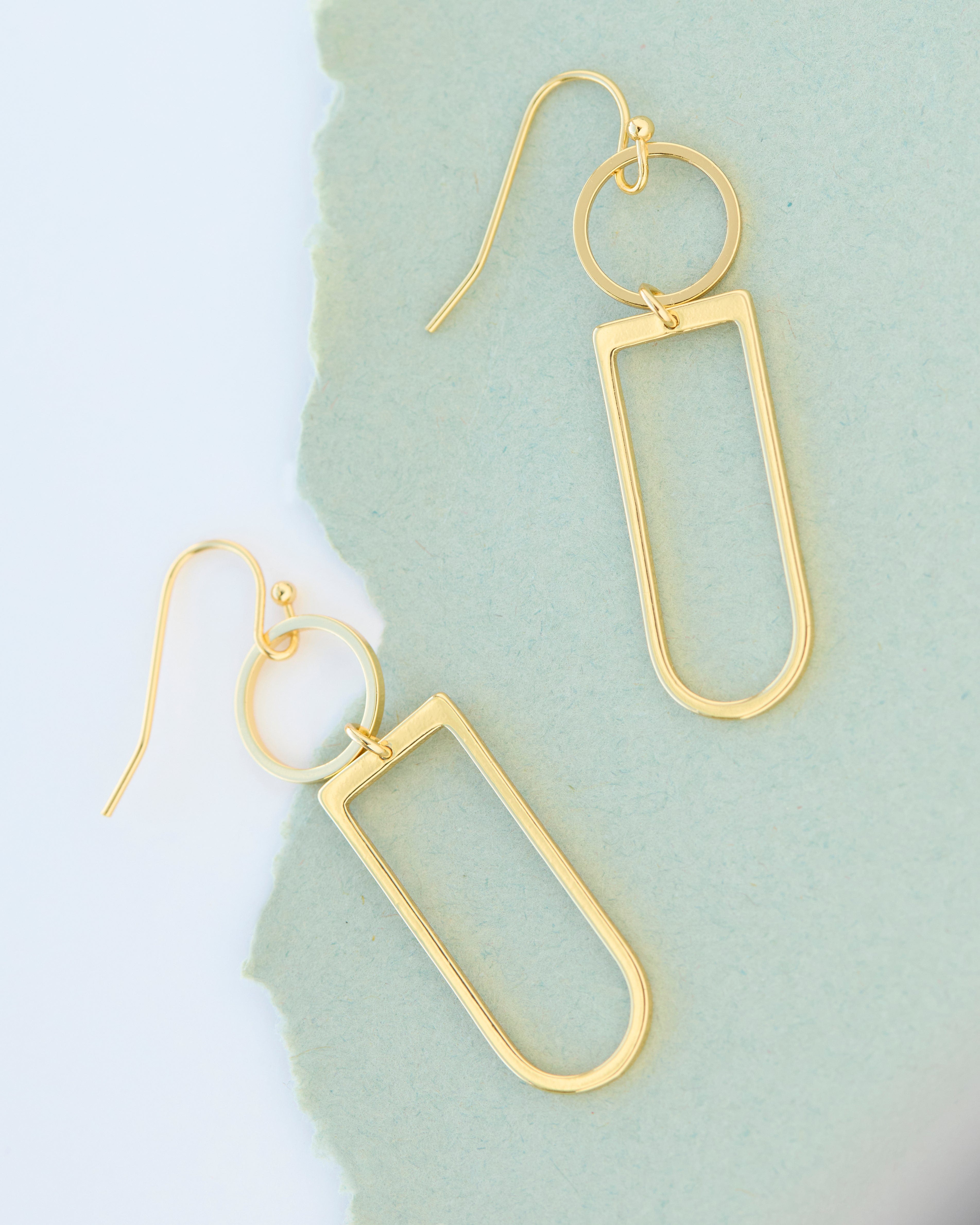 Gold dangle earrings in geometric shapes.