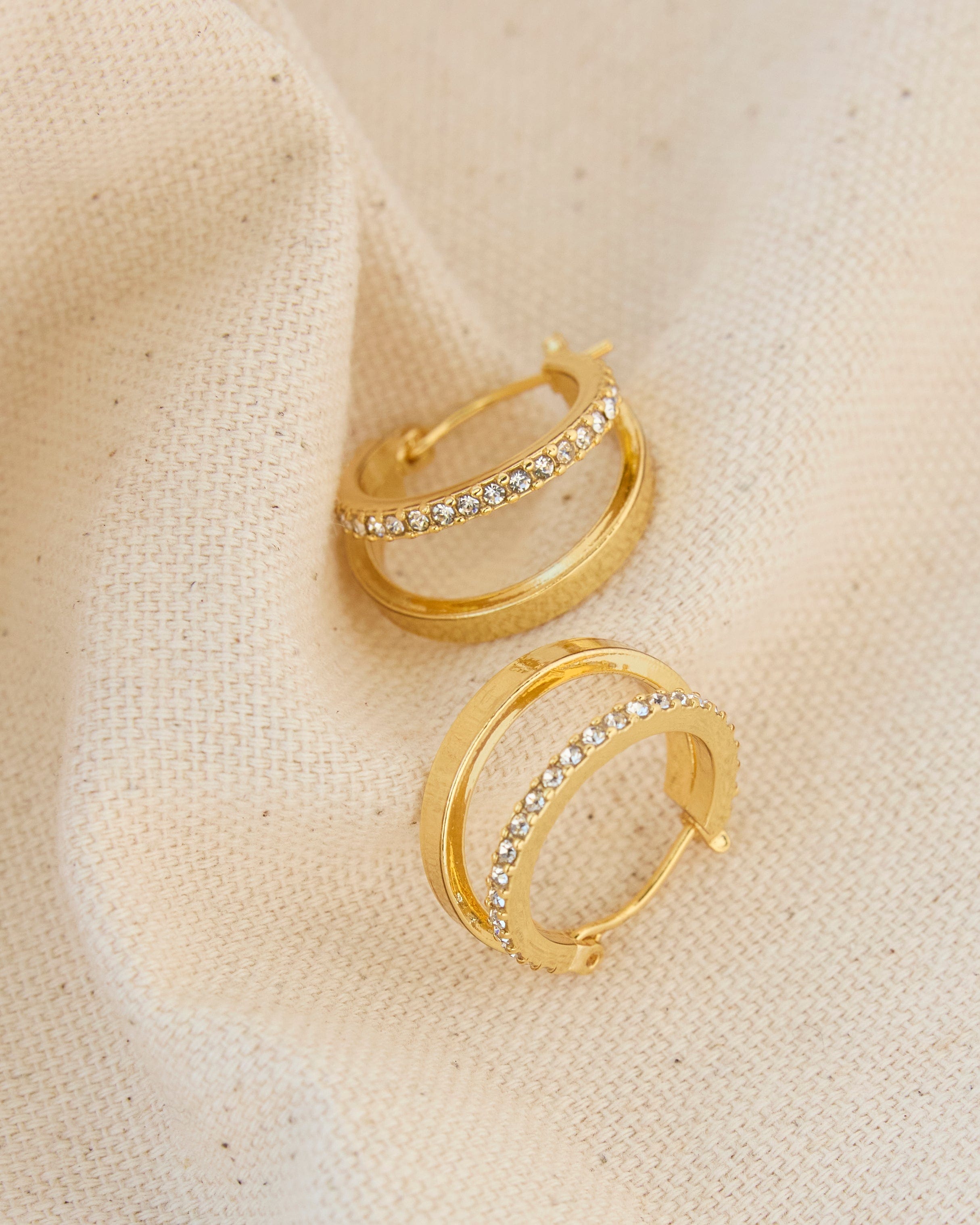 Gold huggie hoop earrings with glass stones.