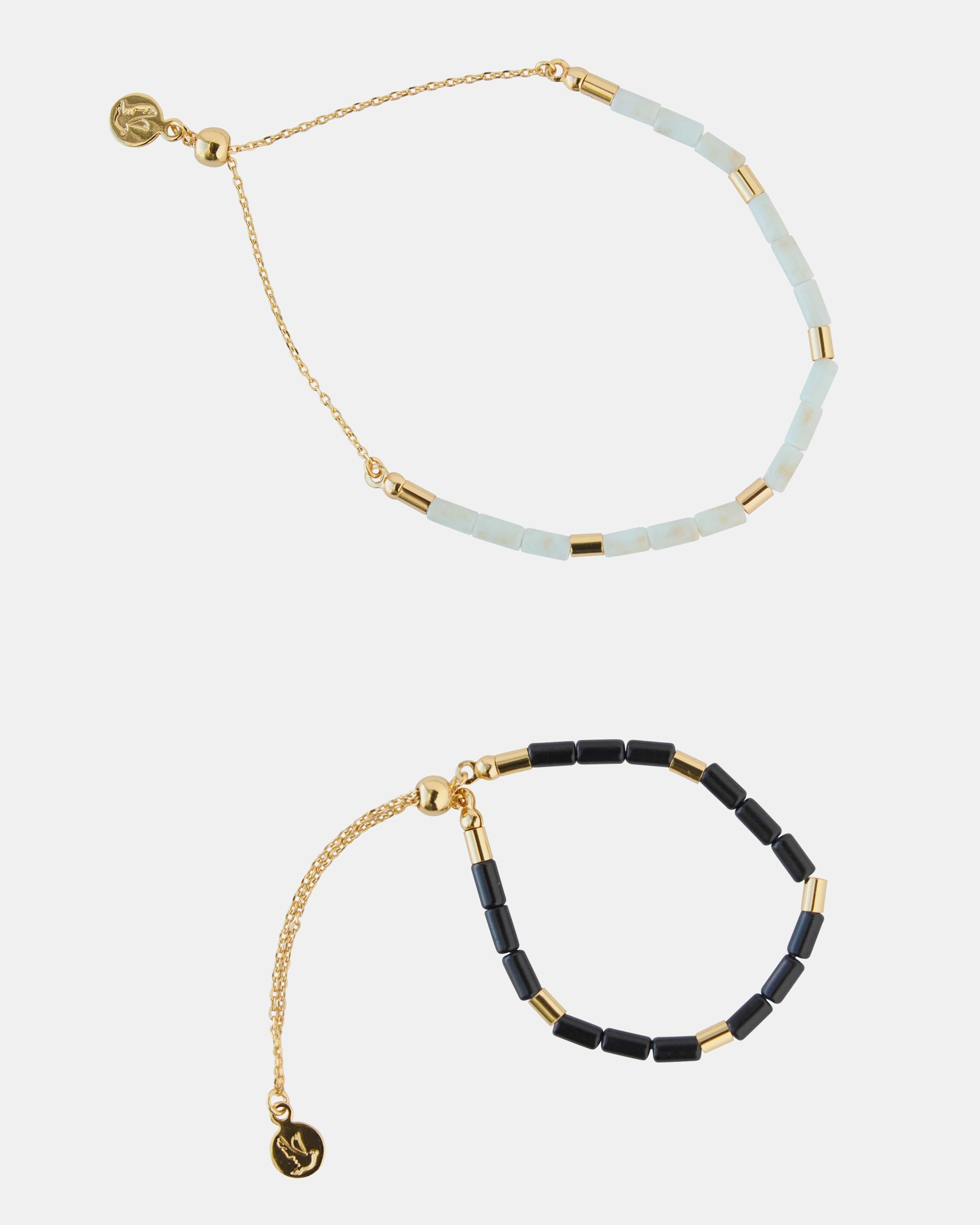 Two-piece bracelet set with gold, black and white beads.