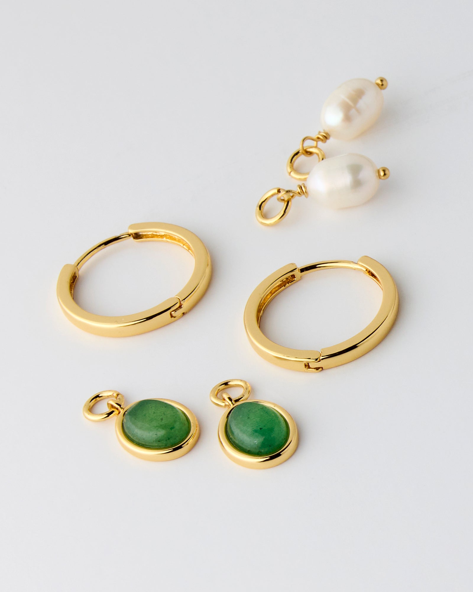 Gold hoops with interchangeable pendants of green stone or pearl
