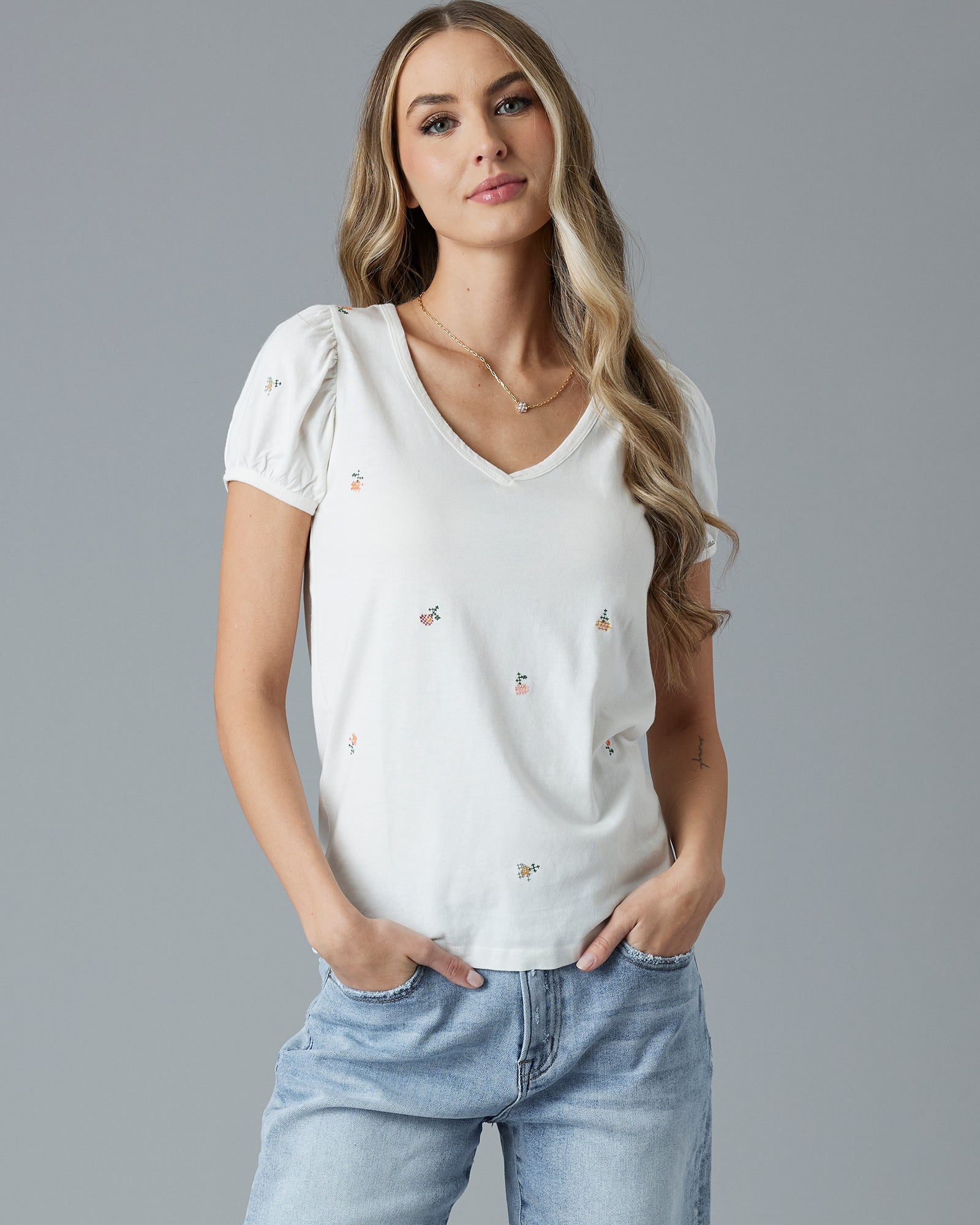 Woman in a white short sleeve t-shirt with floral embroidery