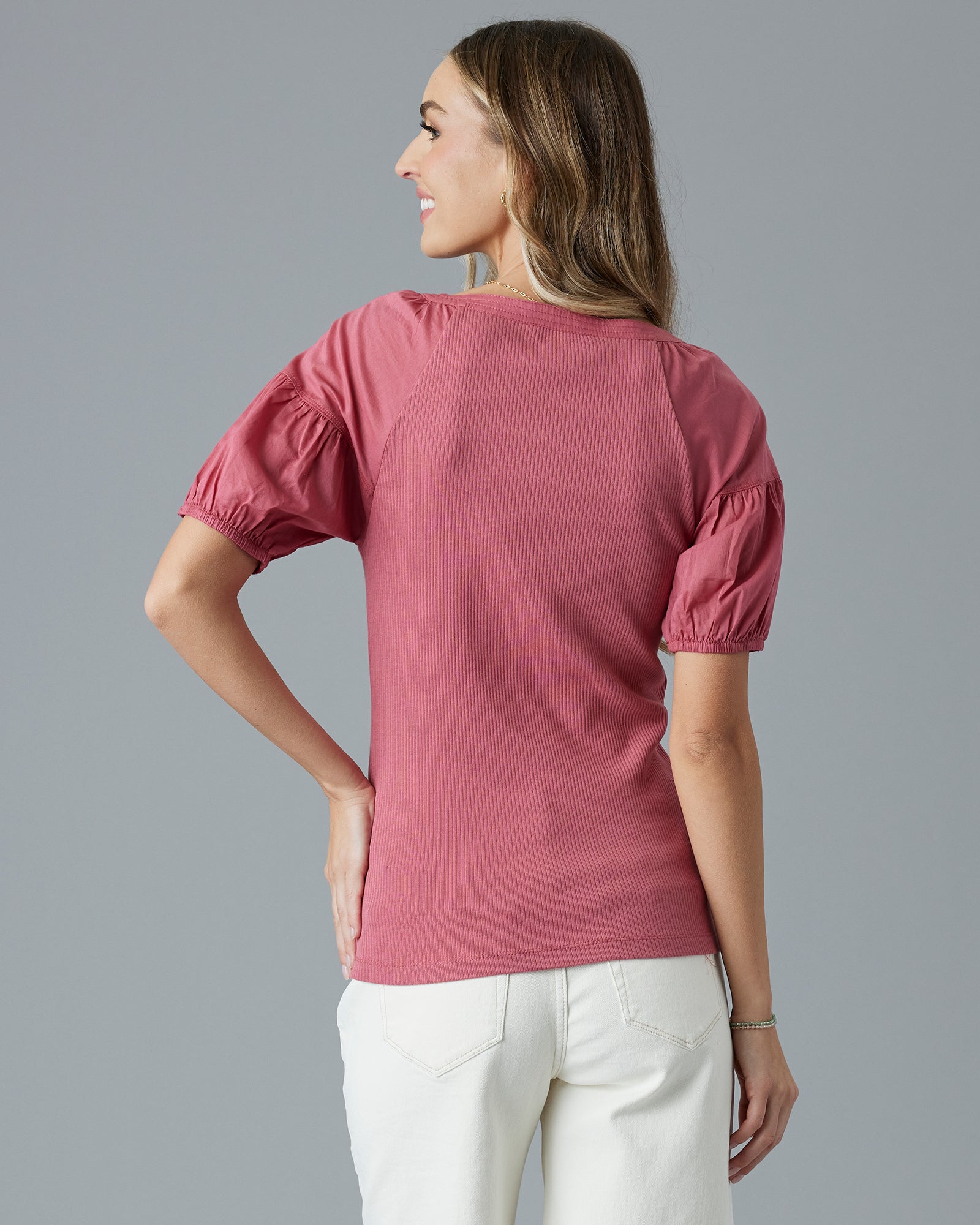 Woman in a pink, short sleeve, ribbed top