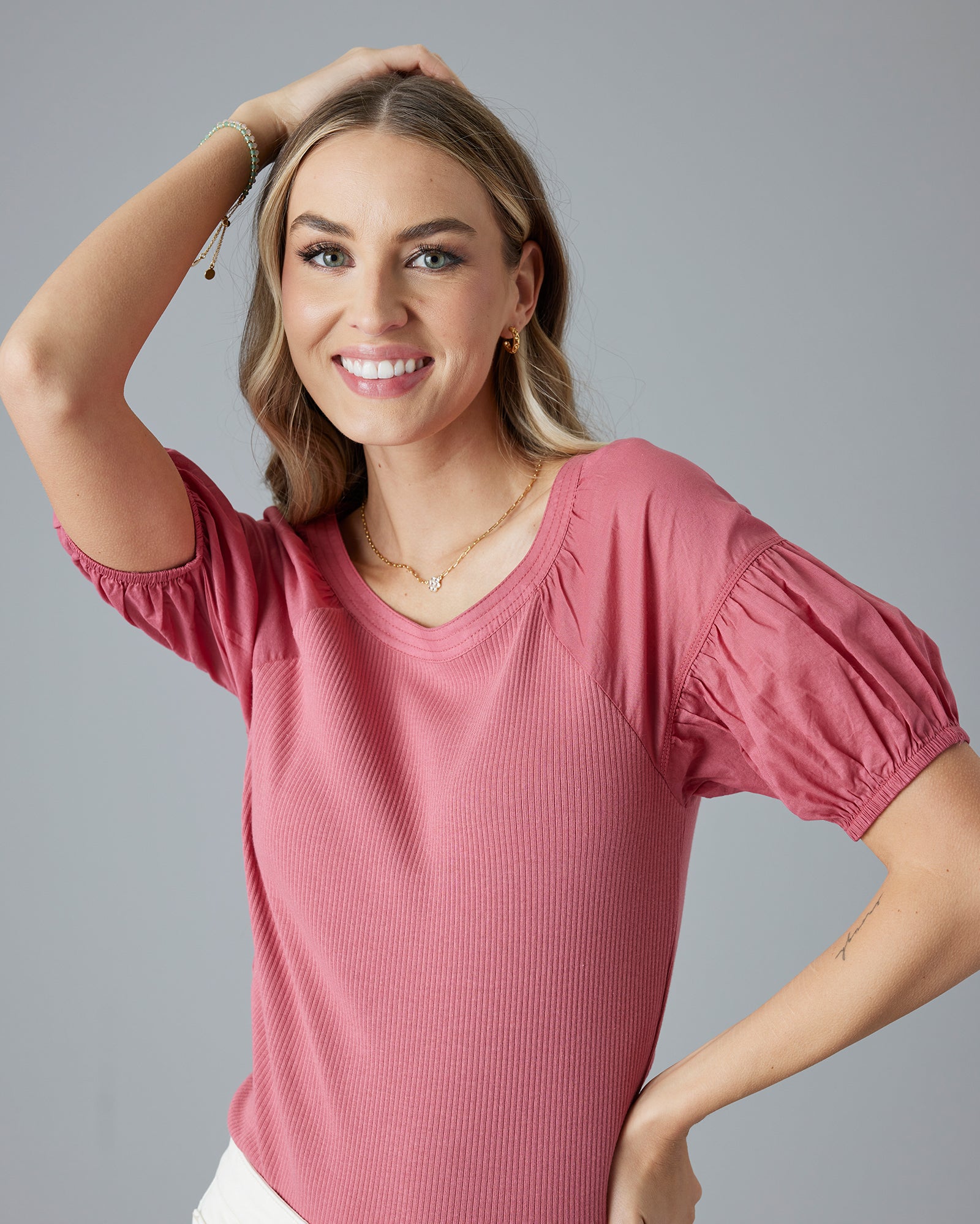 Woman in a pink, short sleeve, ribbed top