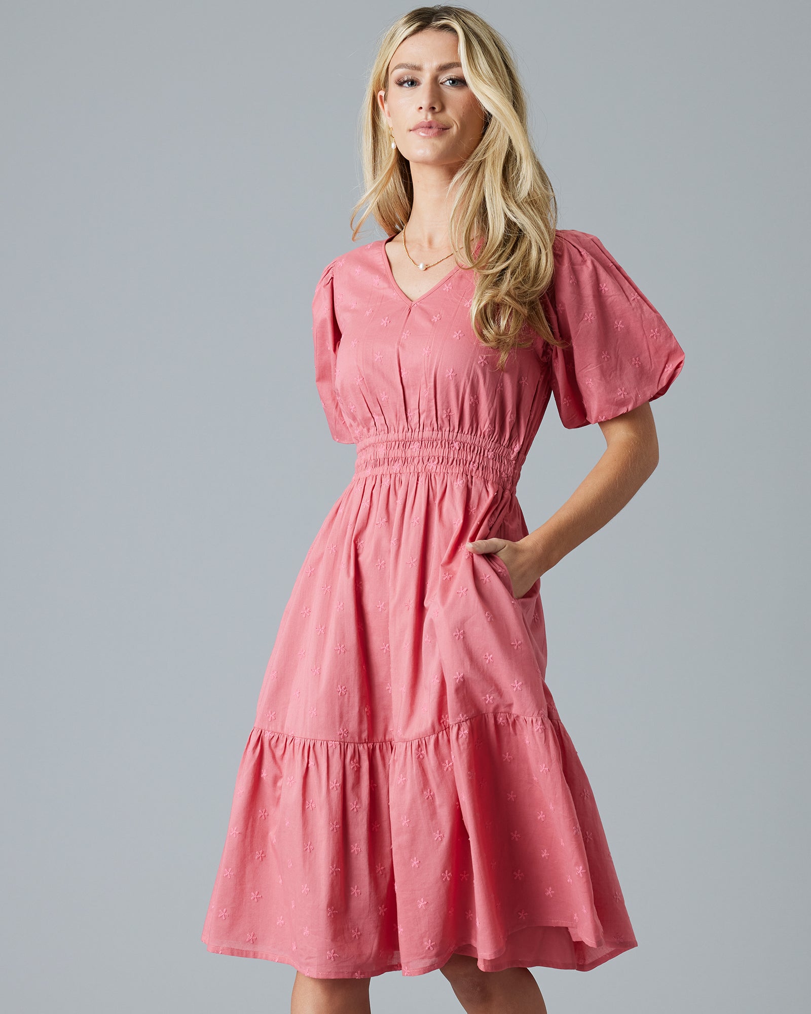 Woman in a rose color, embroidered, short sleeve knee-length dress
