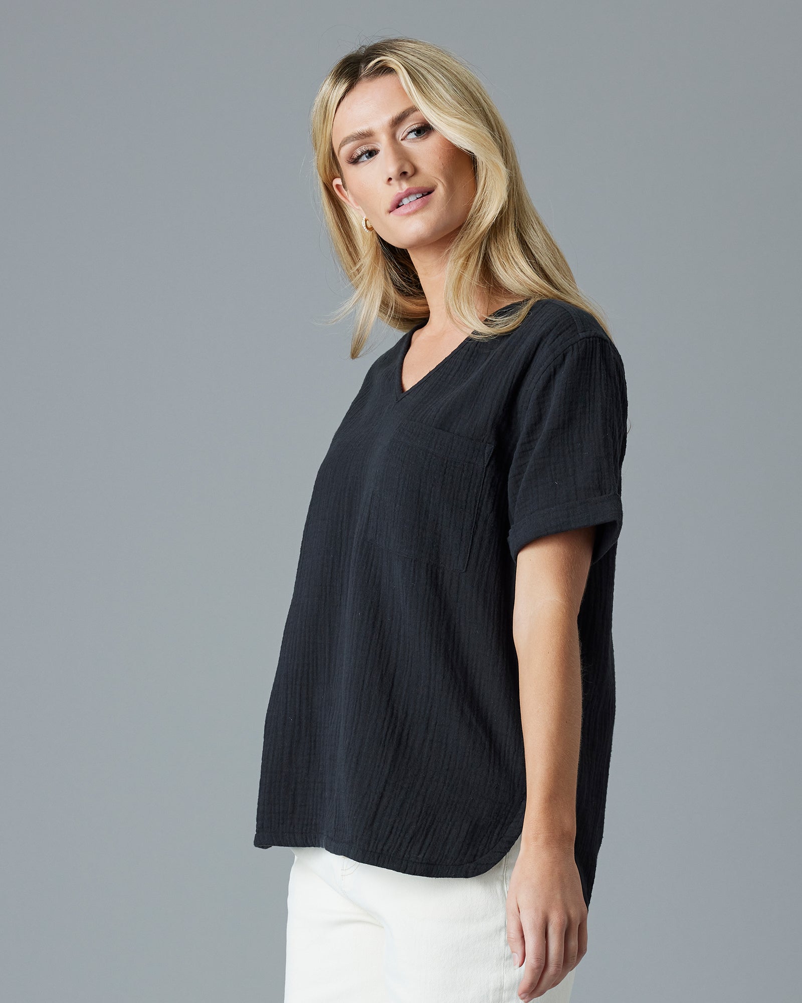 Woman in a black, short sleeved, textured top