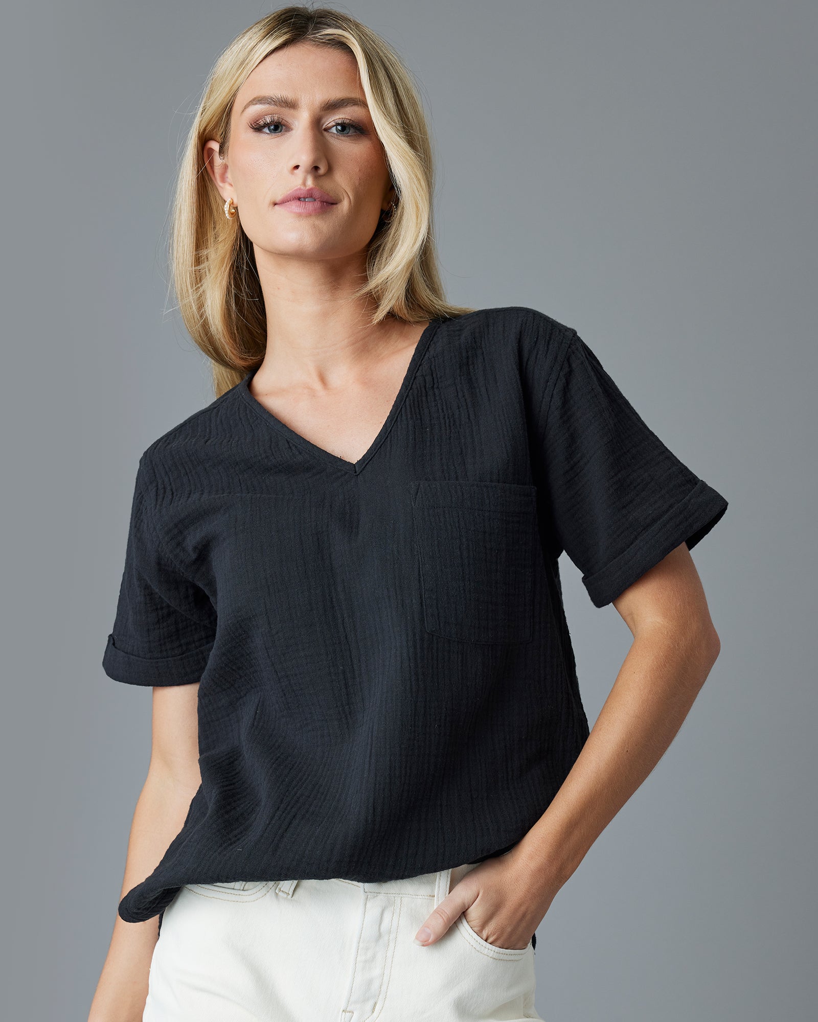 Woman in a black, short sleeved, textured top
