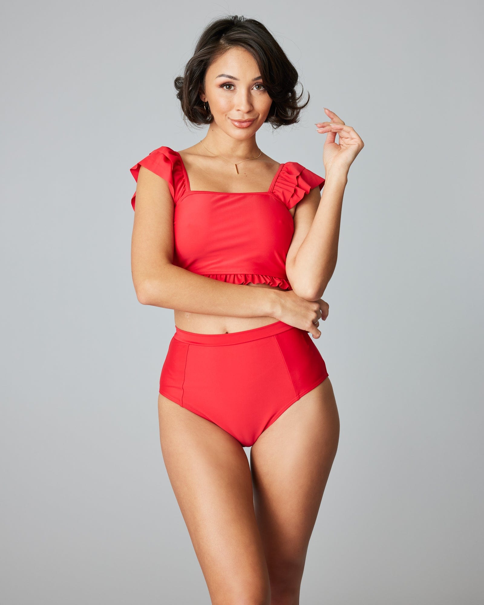Woman in a two-piece swimsuit with a red top.
