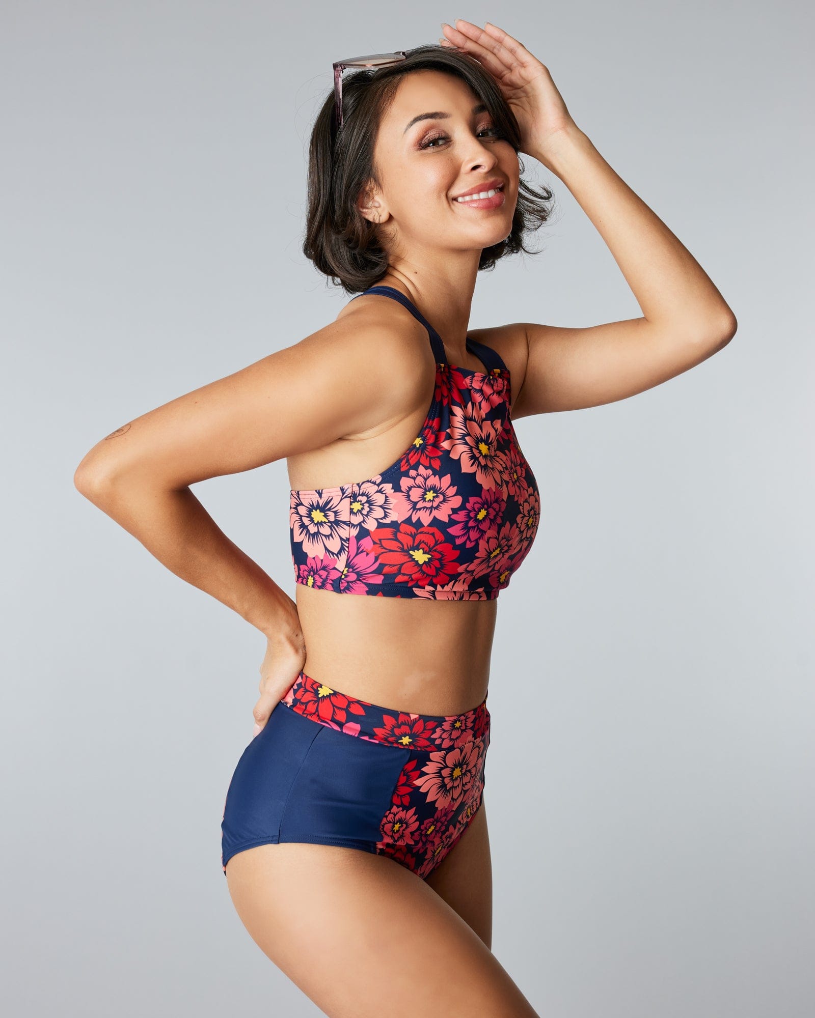 Woman in a two-piece swimsuit with pink flowers on the top and bottom.