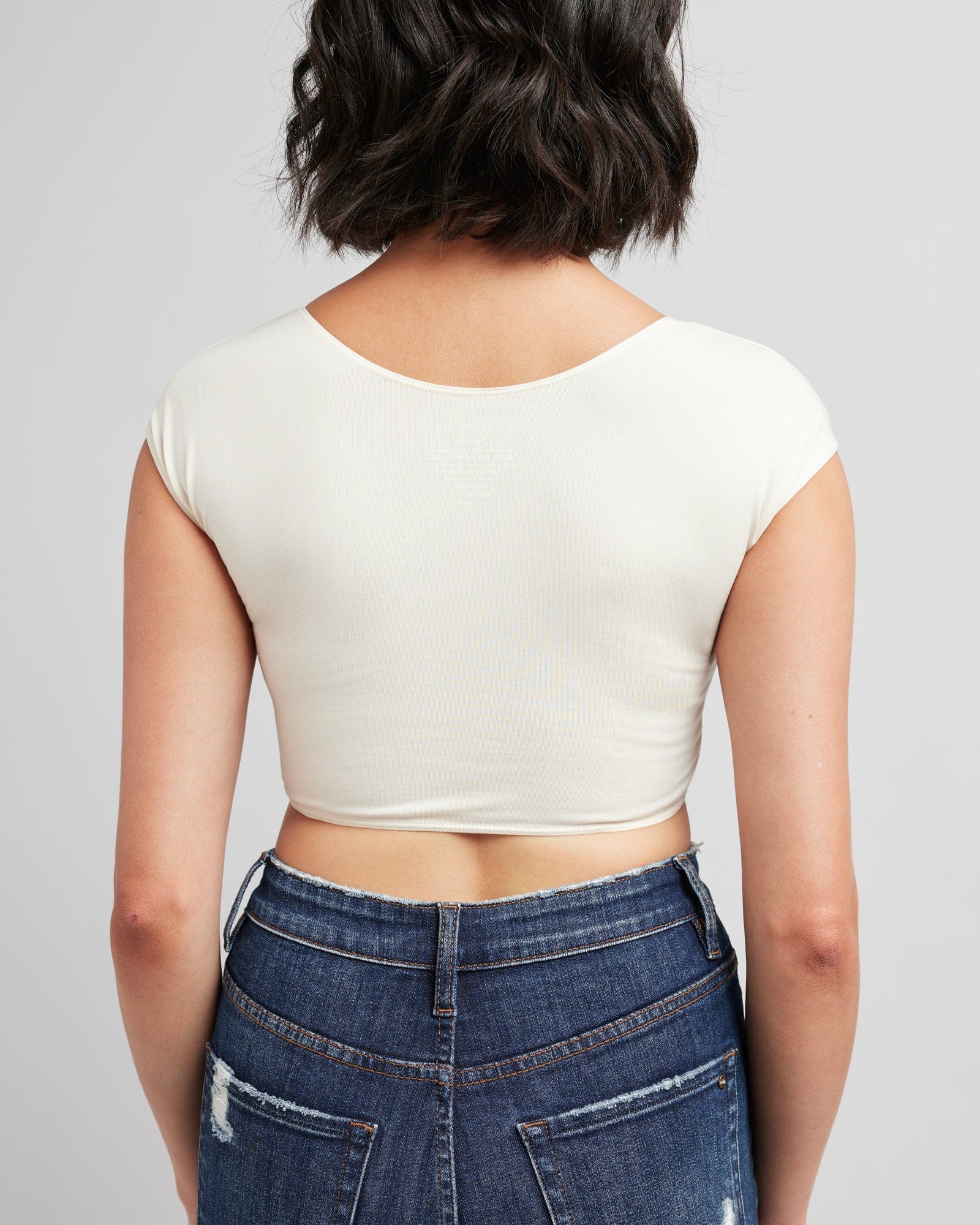 Woman in a cropped, short sleeve, basic tee