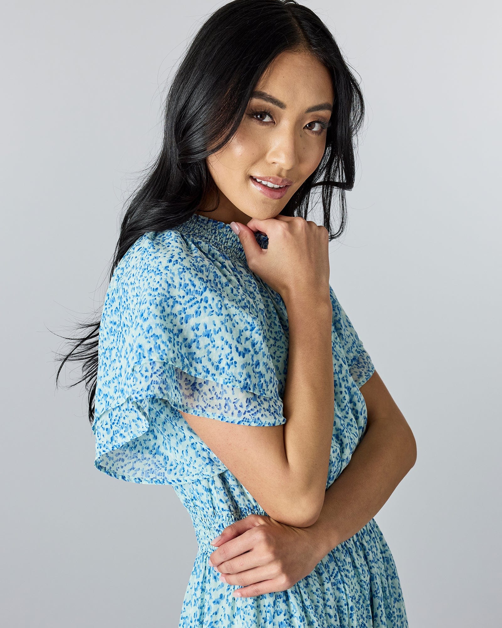 Woman in a blue floral, short sleeves, high neckline, maxi-dress.