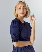 Woman in a blue, midi-length, short sleeve dress.