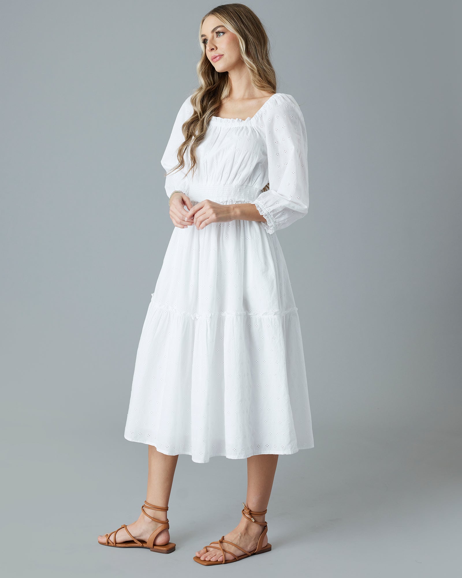 Woman in a white, eyelet midi length dress
