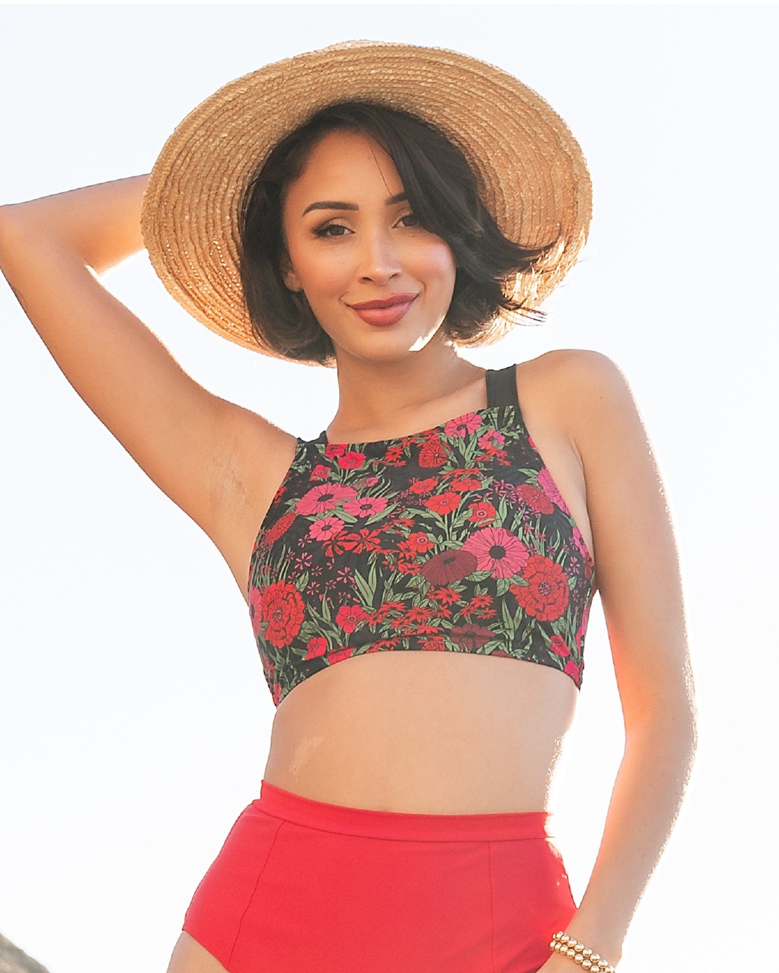 Woman in a two-piece swimsuit with pink and red flowers.