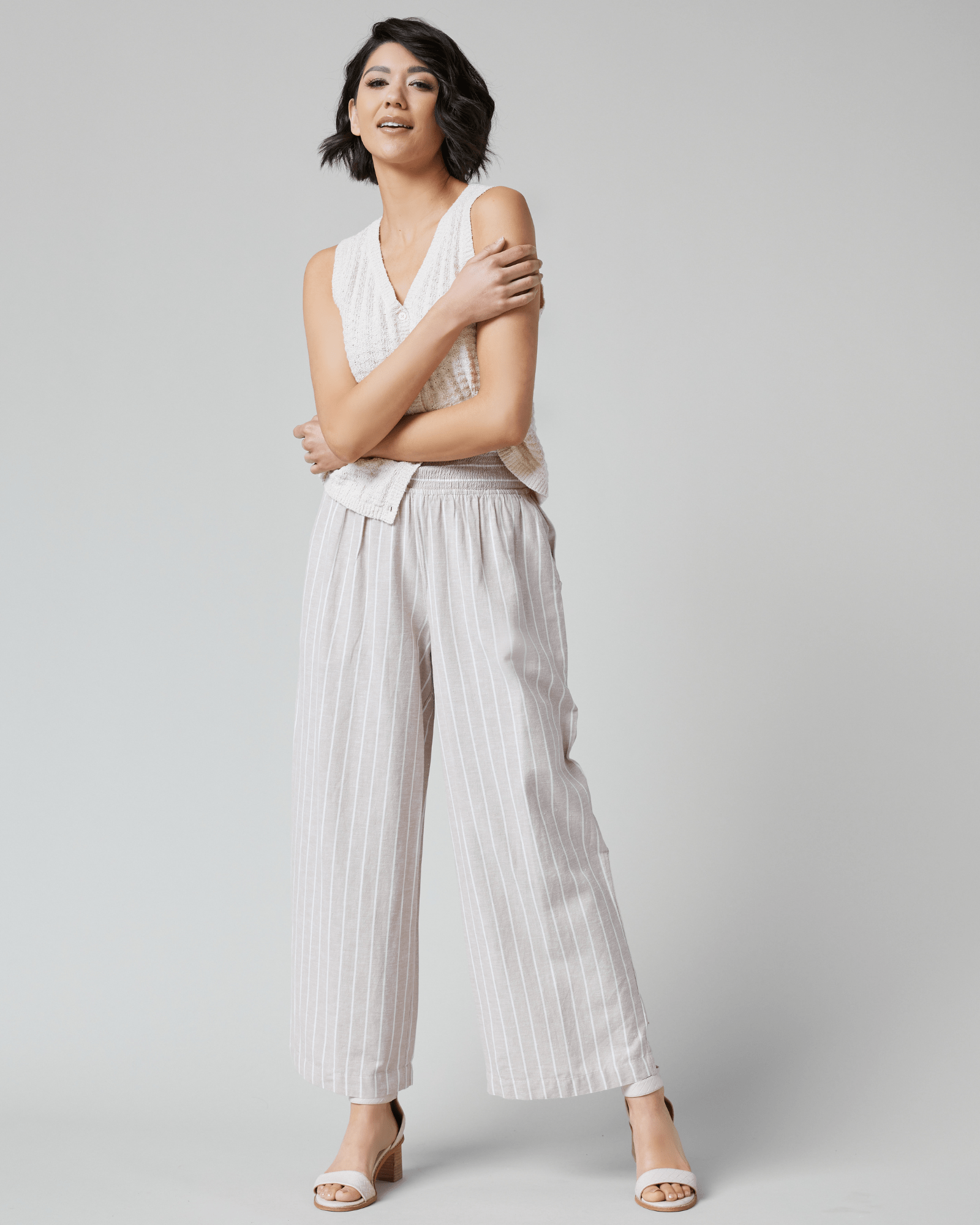 Woman in tan and white vertical striped pants