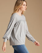 Woman in a gray long sleeve blouse