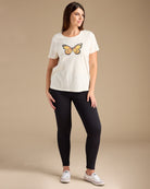 Woman in a white graphic tee with butterfly on front