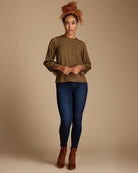 Woman in an olive green long sleeve blouse