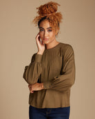 Woman in an olive green long sleeve blouse