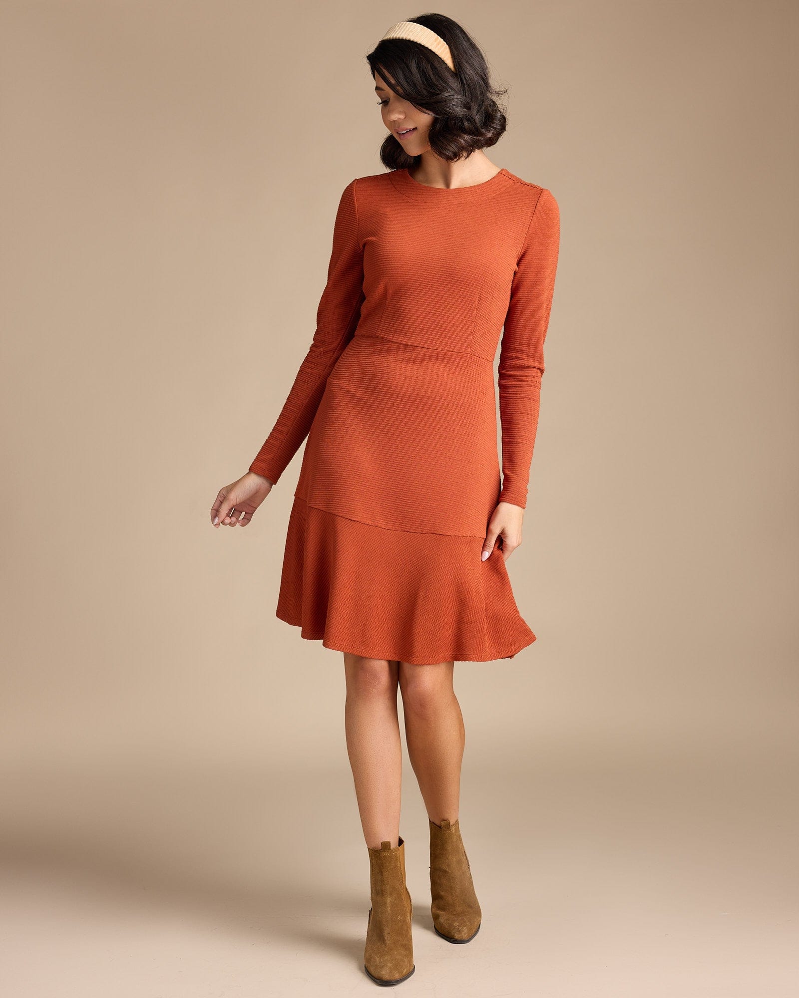 Woman in a long sleeve, knee-length, orange dress