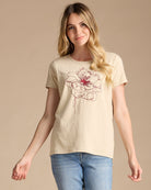 Woman in a yellow graphic tee with a fall bloom embroidered on front
