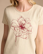 Woman in a yellow graphic tee with a fall bloom embroidered on front