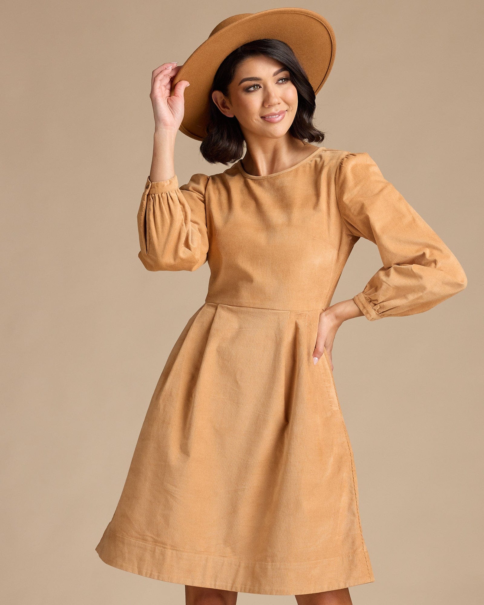 Woman in a long sleeve, knee-length, yellow dress