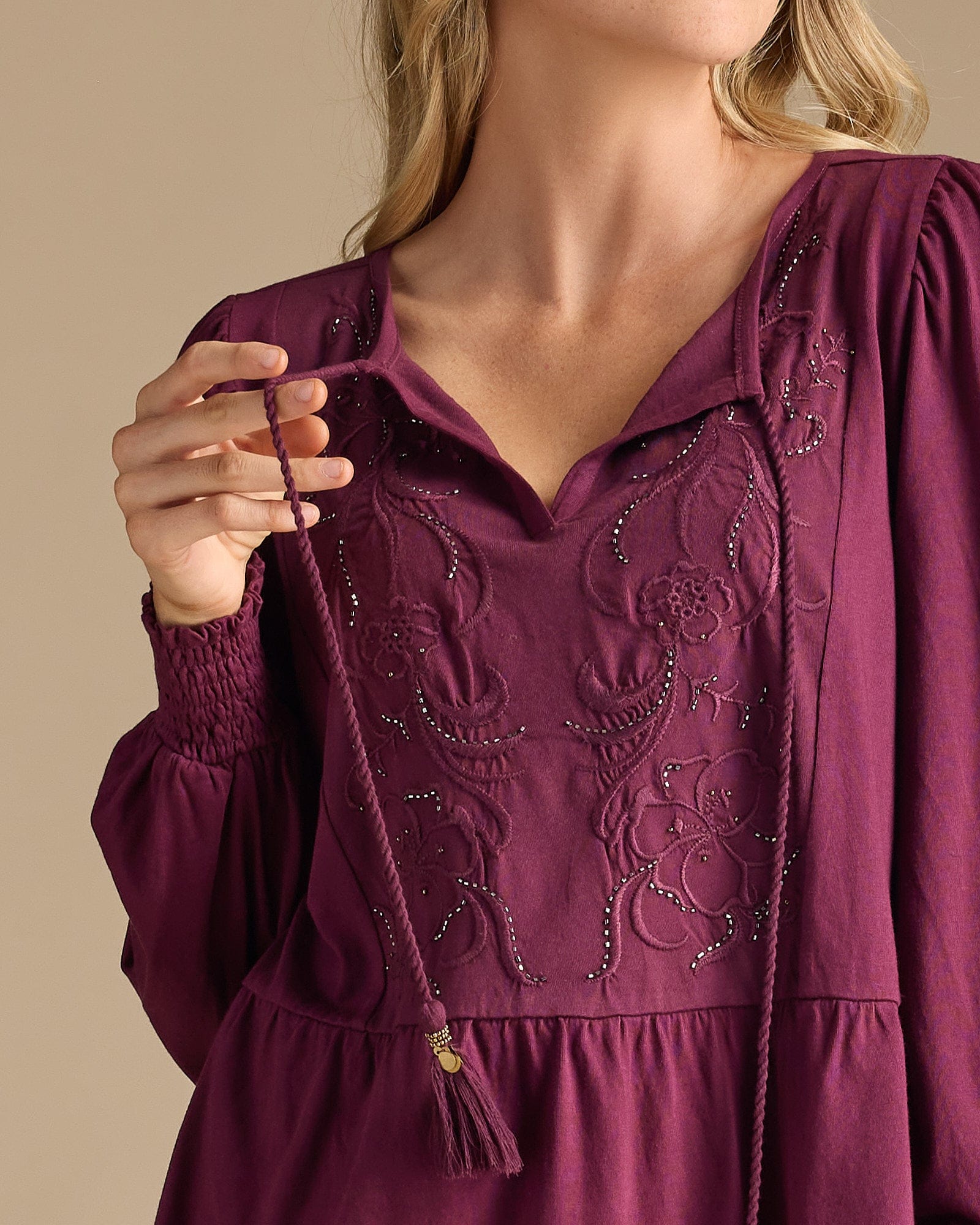 Woman in a purple blouse with peplum gathering and embroidered bib