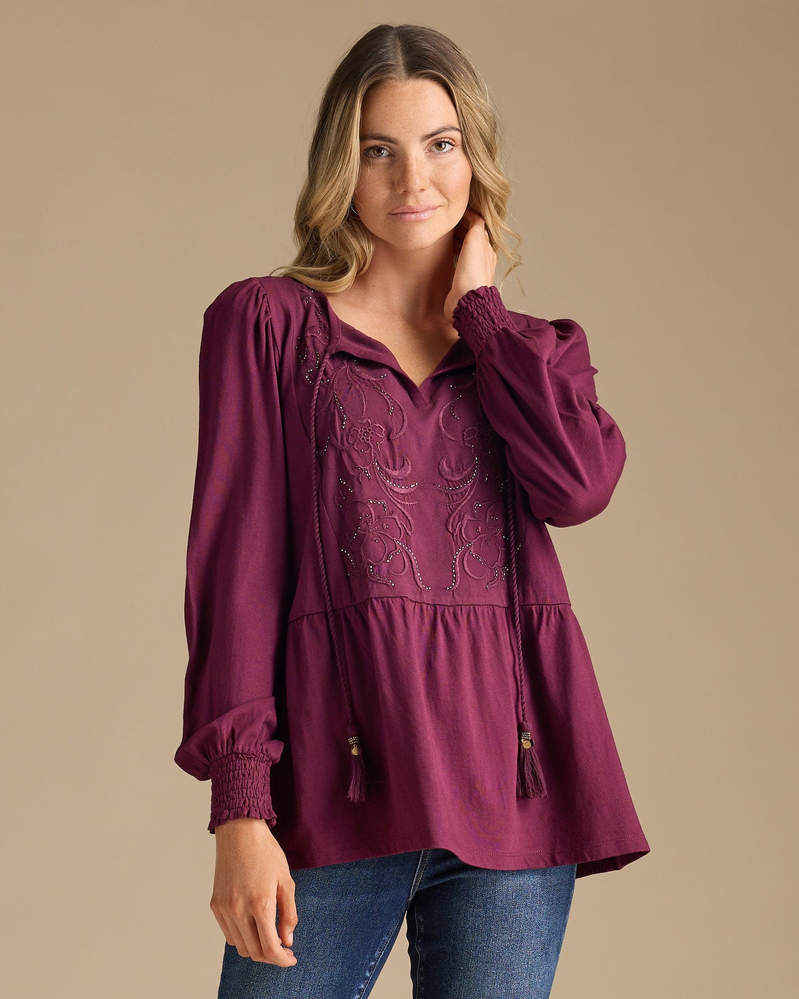 Woman in a purple blouse with peplum gathering and embroidered bib