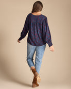Woman in a blue and purple printed long sleeve blouse