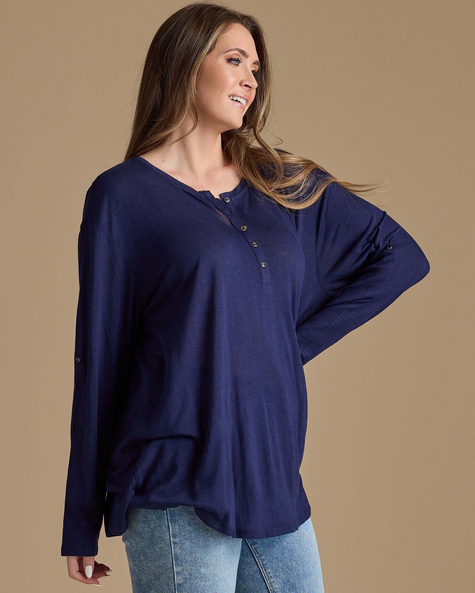 Woman in a navy, long sleeve, oversized, loose fitting blouse
