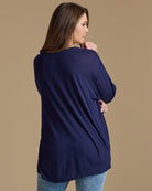 Woman in a navy, long sleeve, oversized, loose fitting blouse