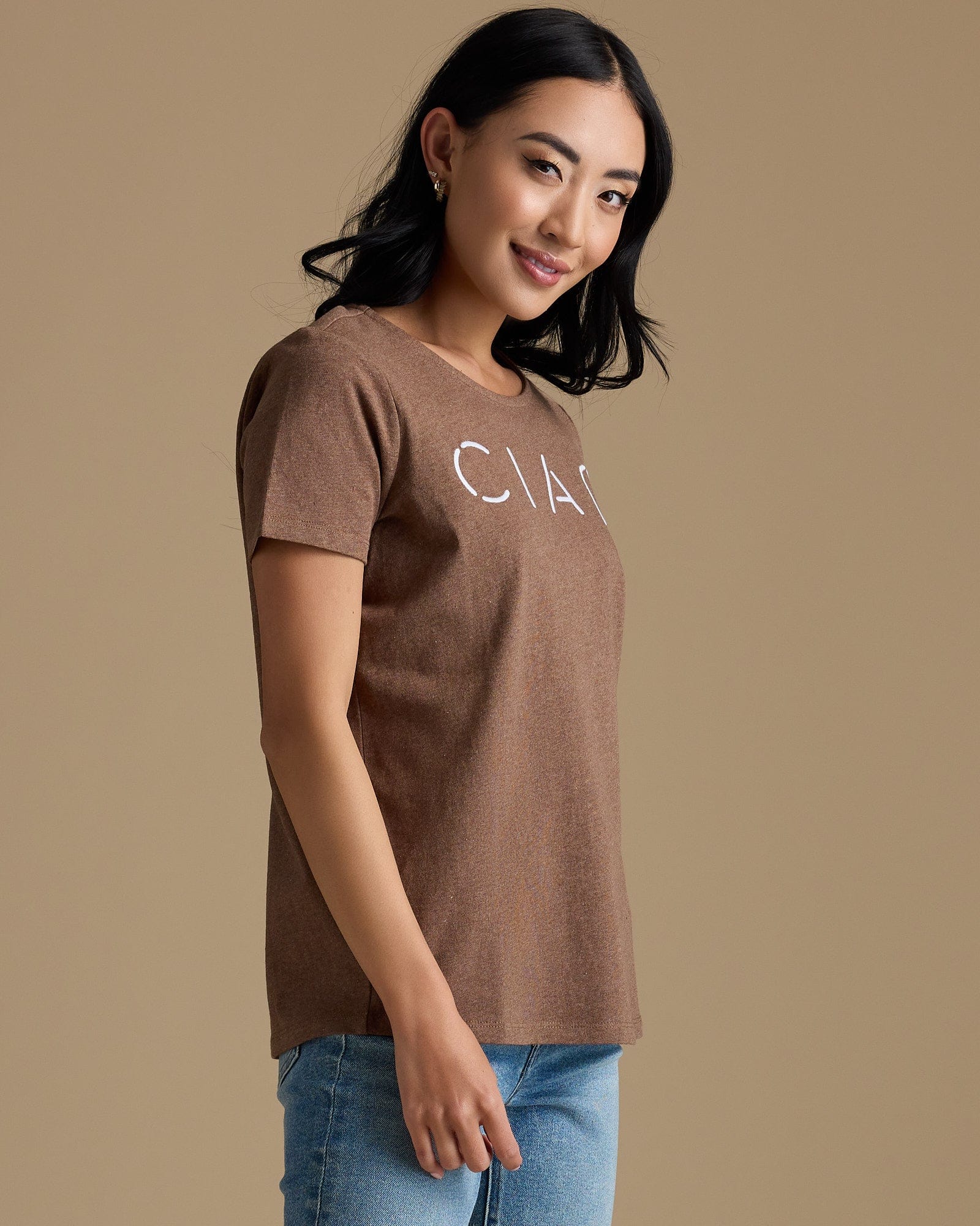 Woman in a brown graphic tee that says "ciao"