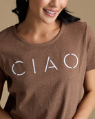 Woman in a brown graphic tee that says "ciao"