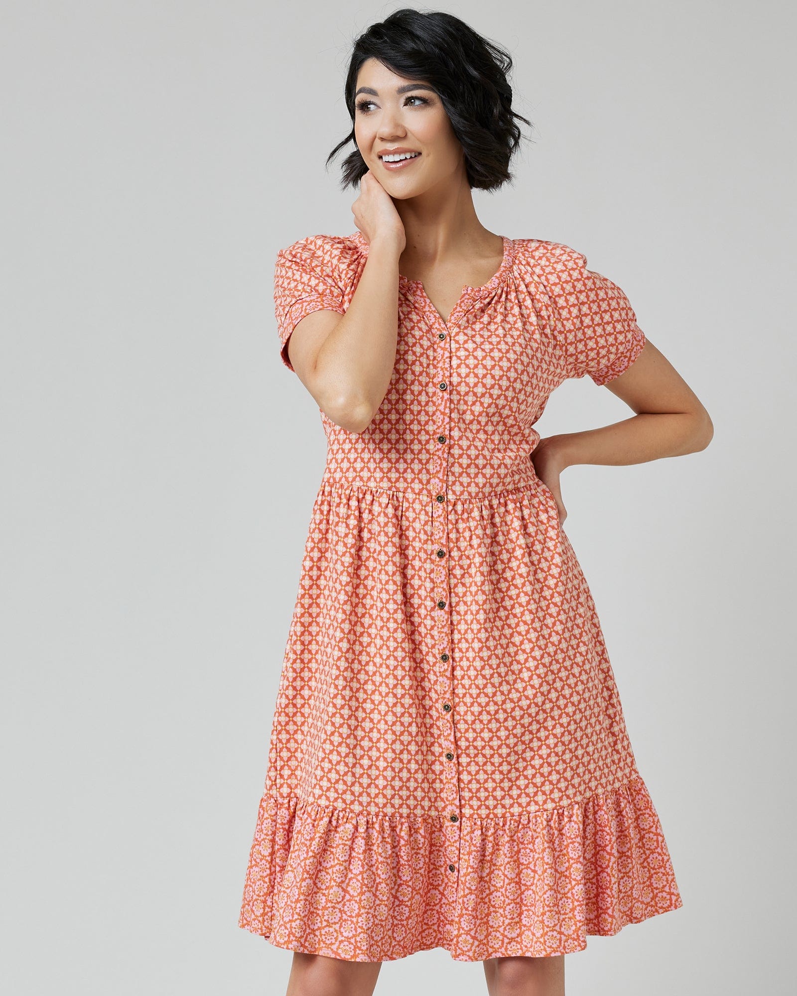 Woman in a short sleeve, knee-length, orange with white polka dot dress