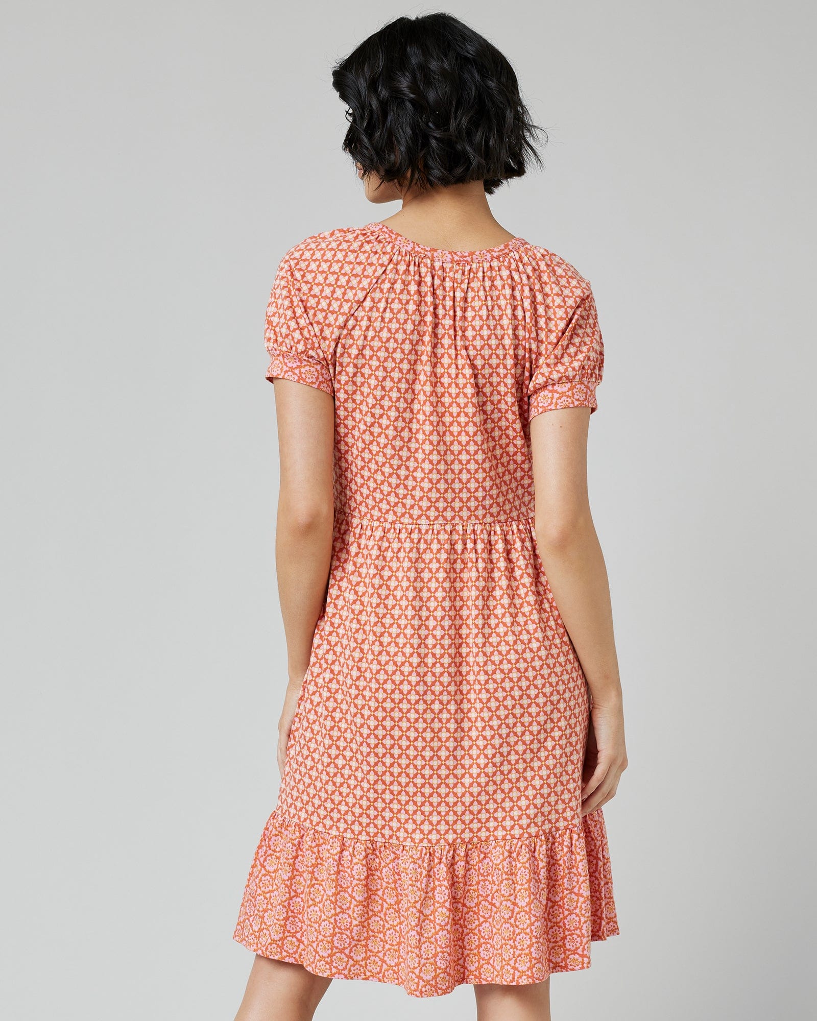 Woman in a short sleeve, knee-length, orange with white polka dot dress