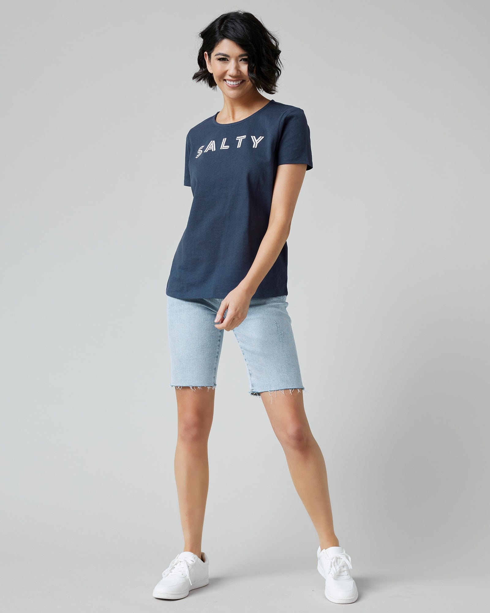 Woman in a navy graphic t-shirt with "SALTY" across the front