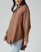 Woman in a brown oversized long sleeve button-down