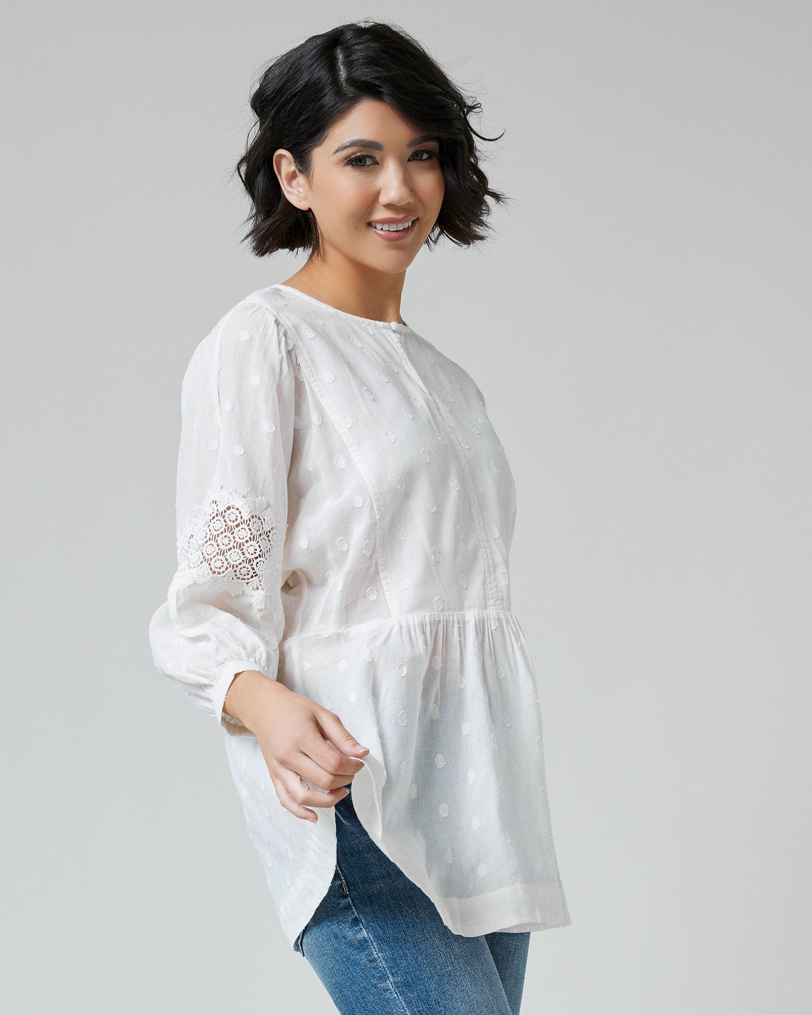 Woman in a white, 3/4 sleeve, peplum blouse