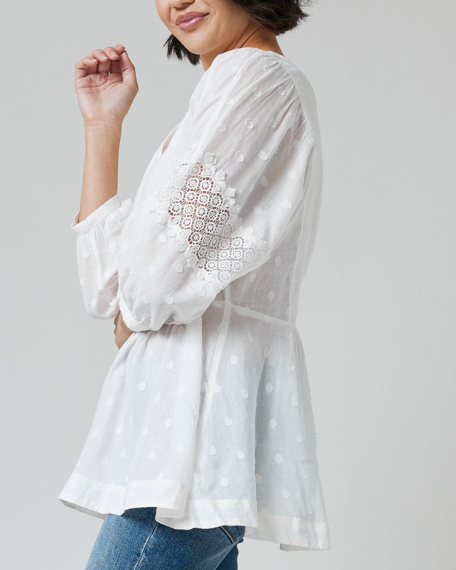 Woman in a white, 3/4 sleeve, peplum blouse