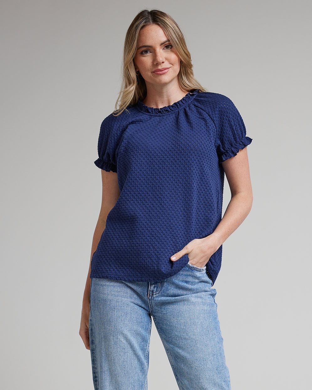 Woman in a short sleeve, mock neck with ruffles blouse
